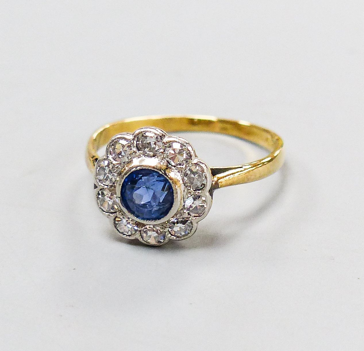 A yellow metal, sapphire and diamond cluster set flower head ring, size G, gross weight 1.6 grams.